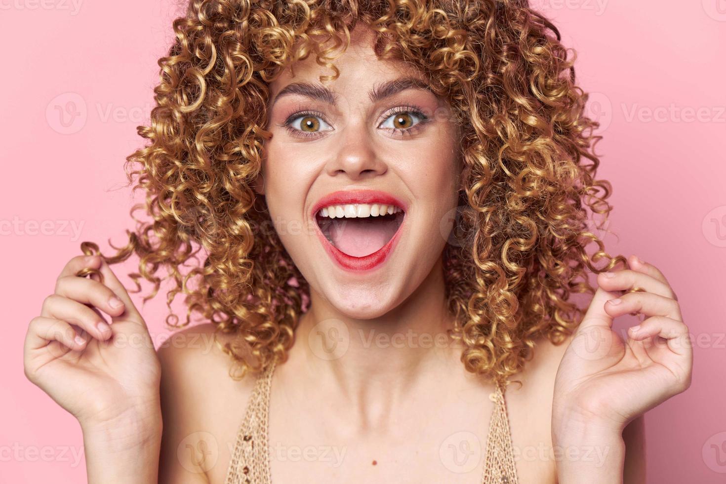 Pretty woman Curly hair joyful look Wide smile pink background photo
