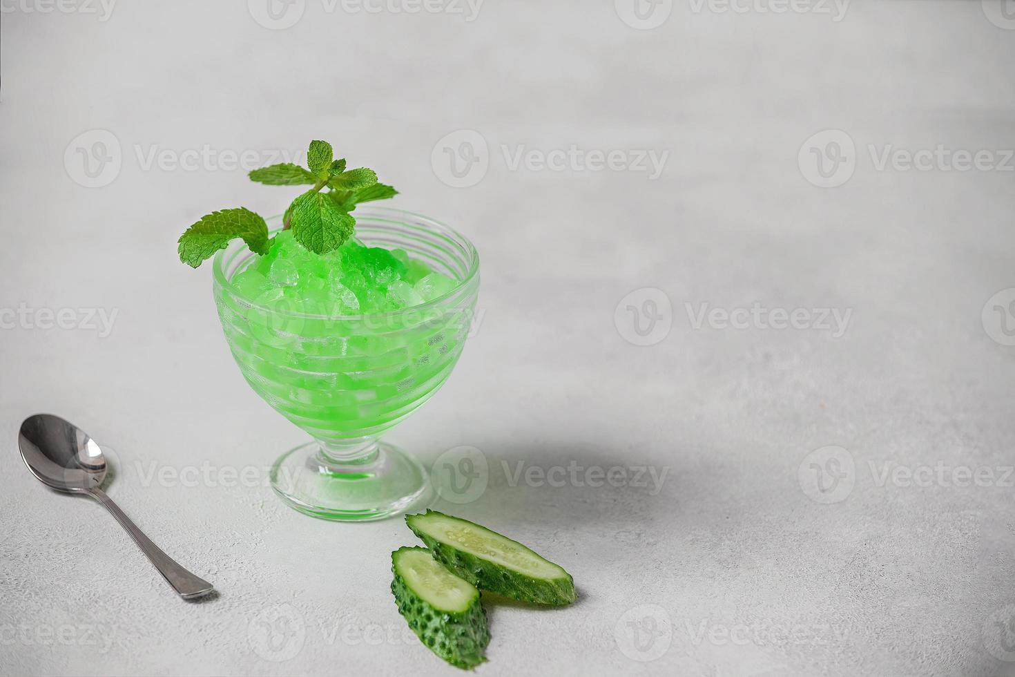 Summer cocktail frozen juice of fresh cucumber and mint on a white minimalist background, copy space. Summer coolness, a tonic cocktail of crushed ice, a kind of sherbet. photo