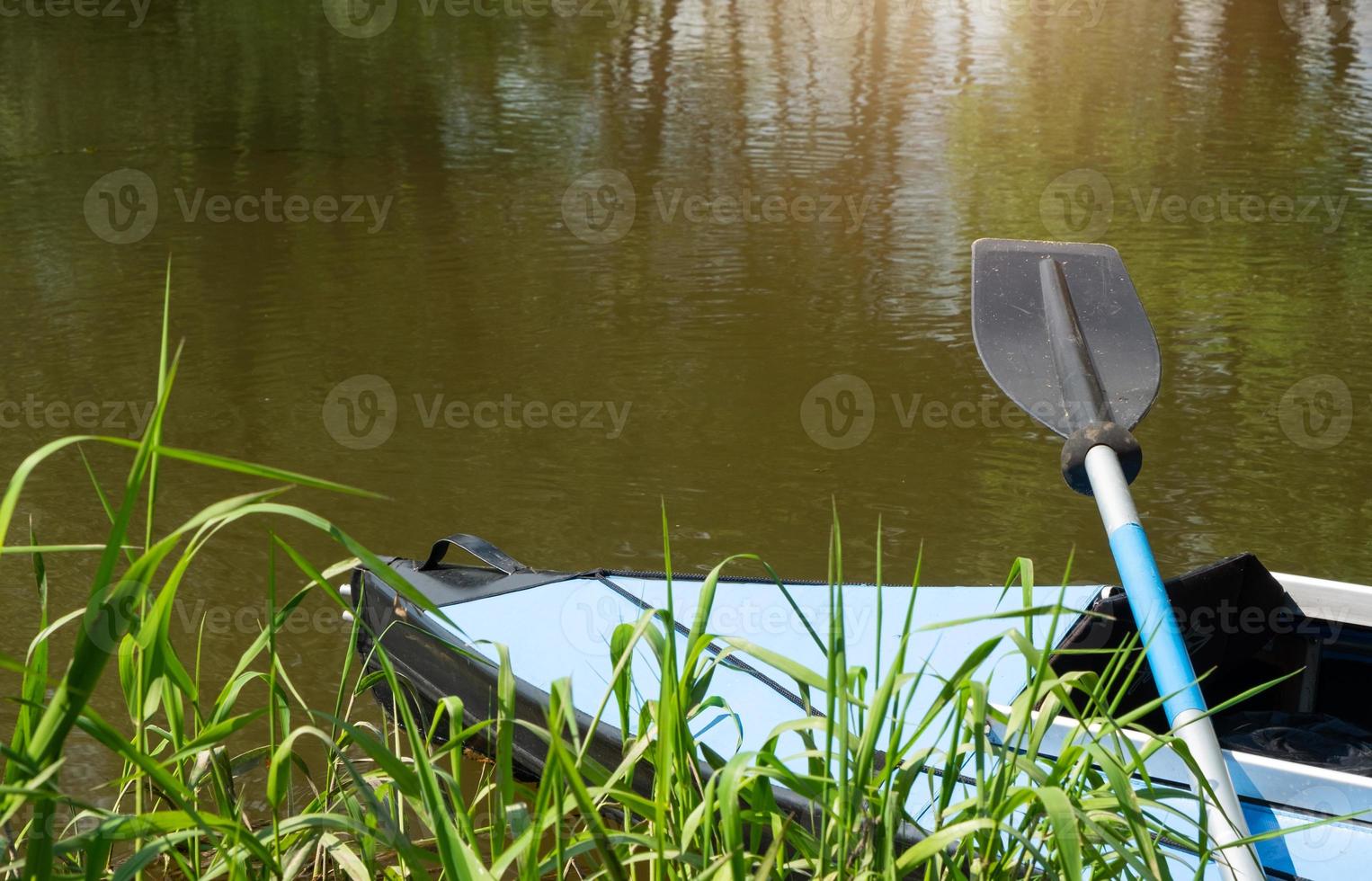 Tourist canoes with paddles stand on the river coast in summer on a water hike. Rafting on inflatable and frame double and triple kayak boats, family trip, extreme adventure in summer photo