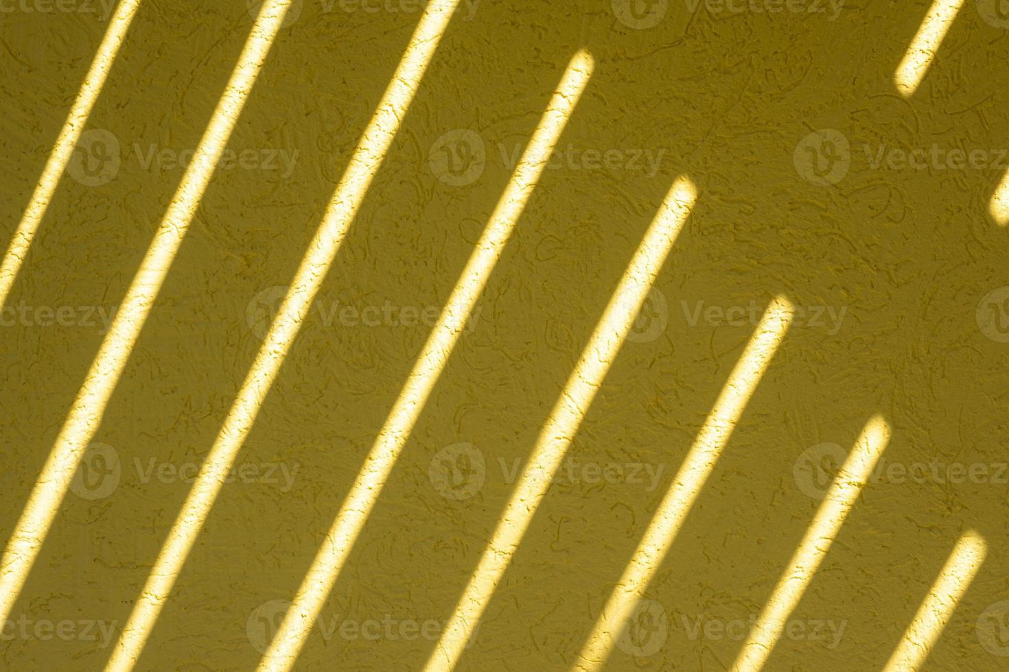 Yellow texture of the wall with a bark beetle pattern and light stripes. Summer bright sunny background photo