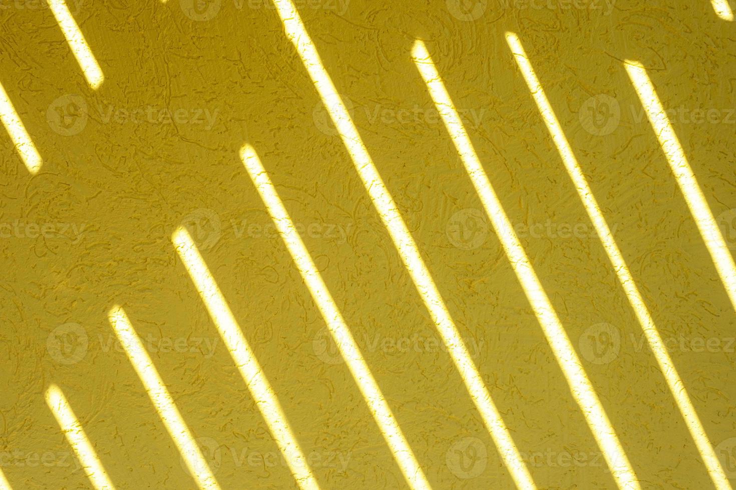 Yellow texture of the wall with a bark beetle pattern and light stripes. Summer bright sunny background photo