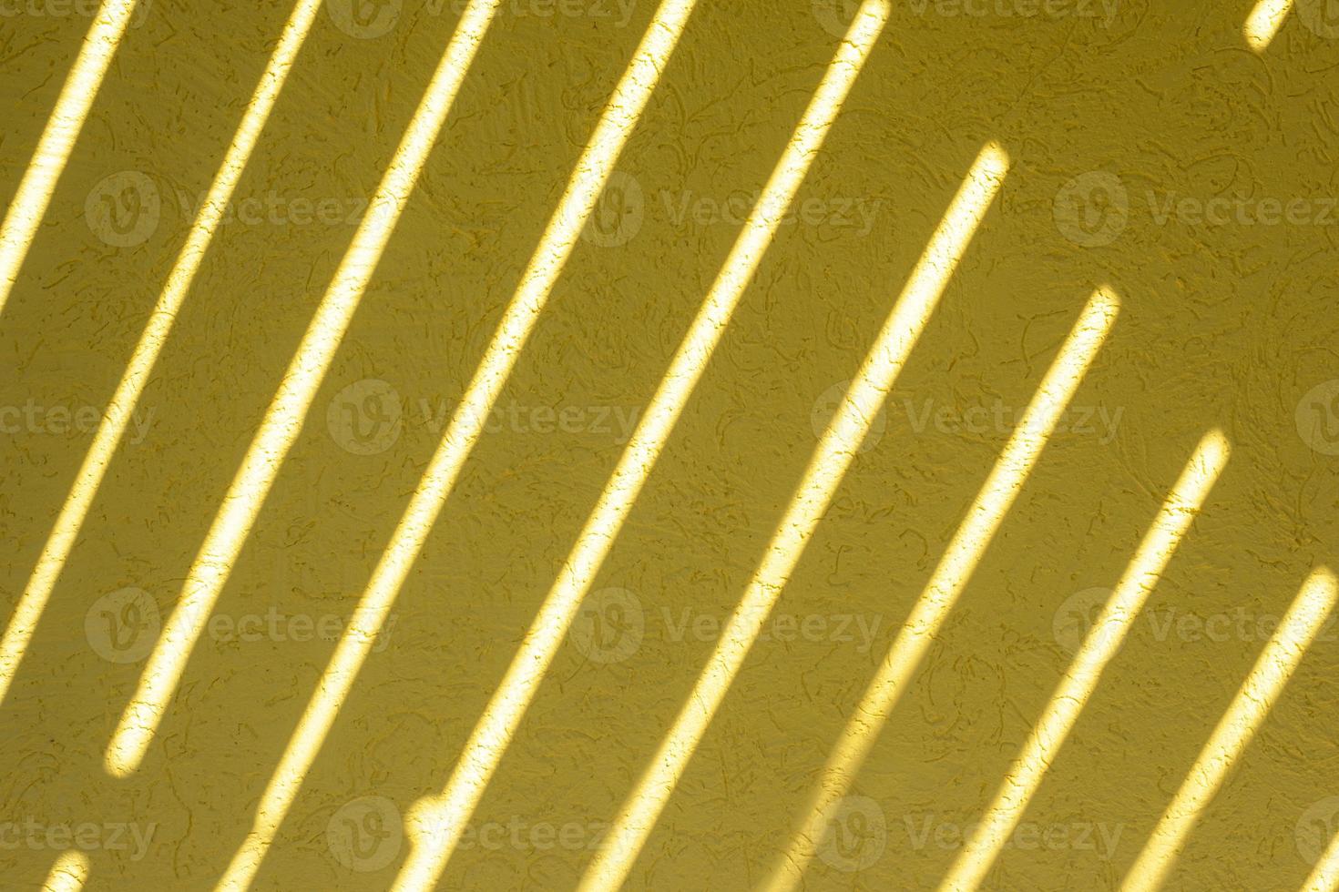 Yellow texture of the wall with a bark beetle pattern and light stripes. Summer bright sunny background photo