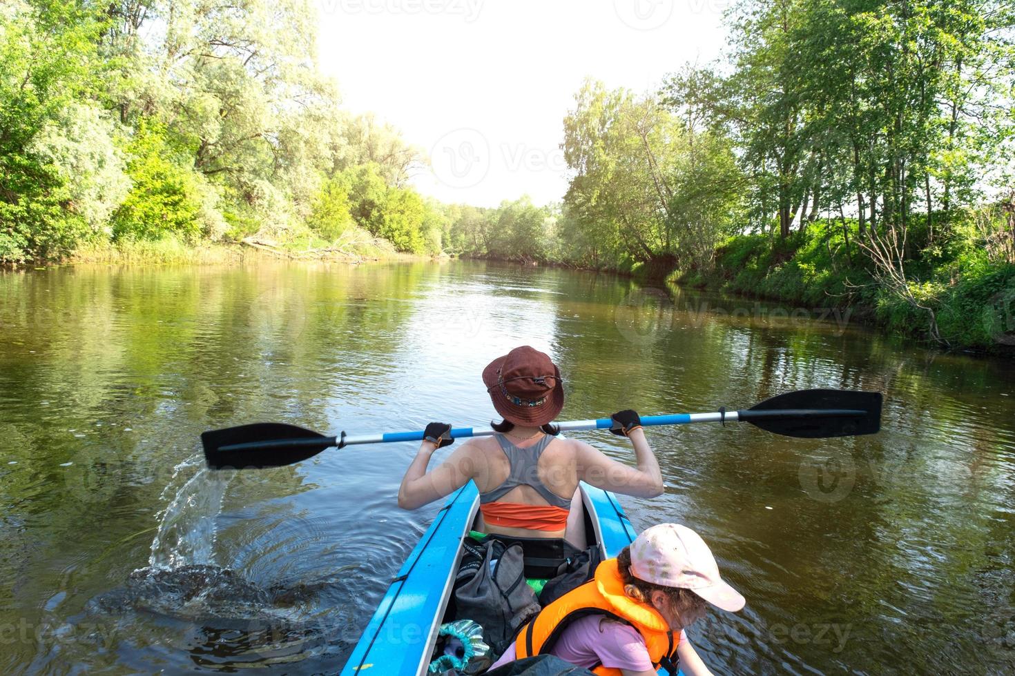 Family kayak trip. Mom and daughter rowing a boat on the river, a water hike, a summer adventure. Eco-friendly and extreme tourism, active and healthy lifestyle photo