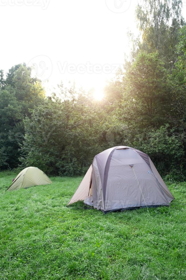 Installed tourist tent in a camping in nature in the forest. Domestic tourism, active summer holidays, family adventures. Ecotourism, sport, hike. mock up photo