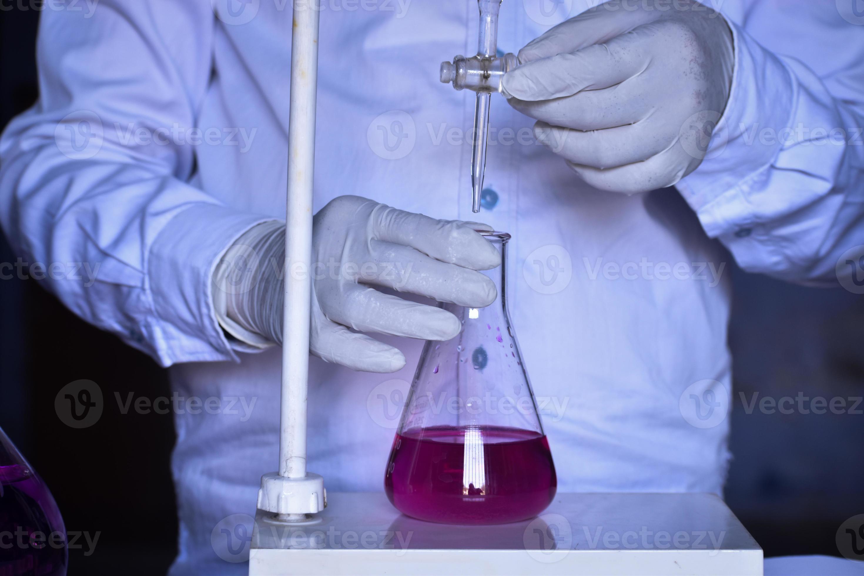 The chemist adds solutions with precision, ensuring accurate