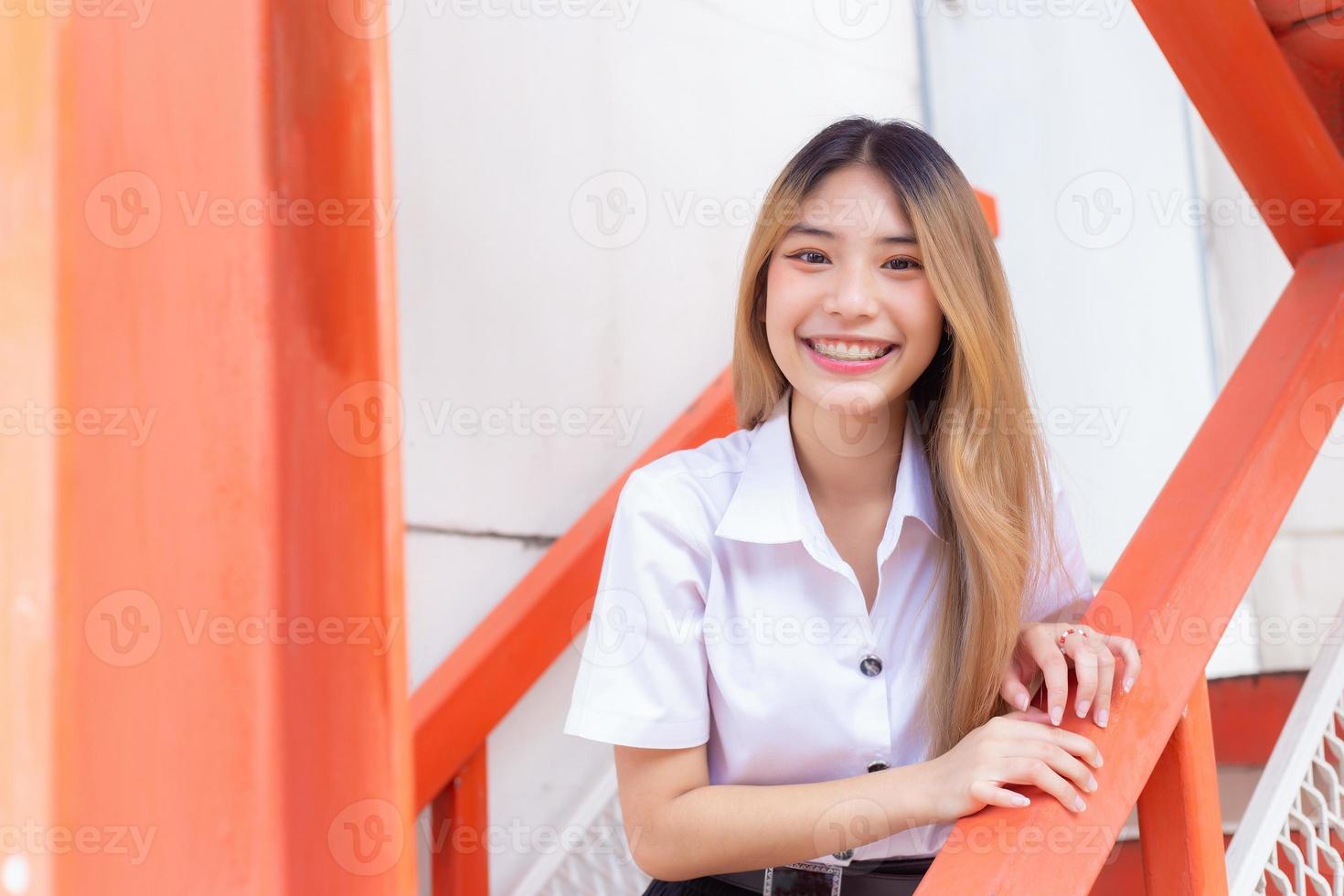 Portrait of young Thai student in university student uniform. Asian cute  girl standing smiling happily and where her teeth are wearing retainers  looking at the camera to present something confidently. 22649252 Stock