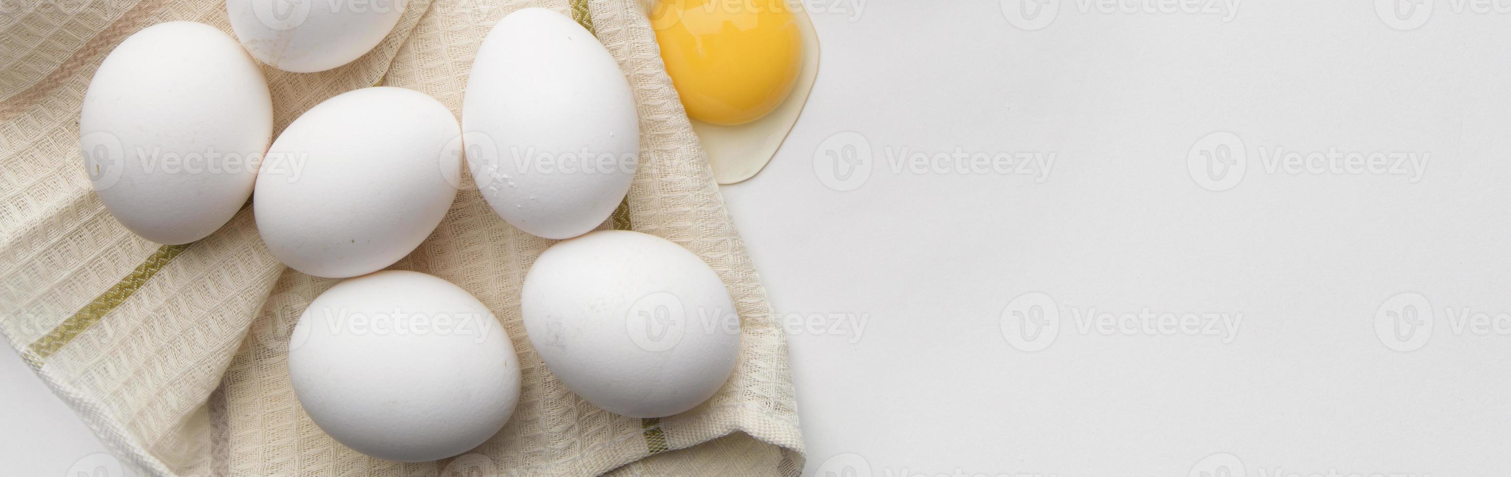 Lots of eggs and a broken egg on the tea towel. photo