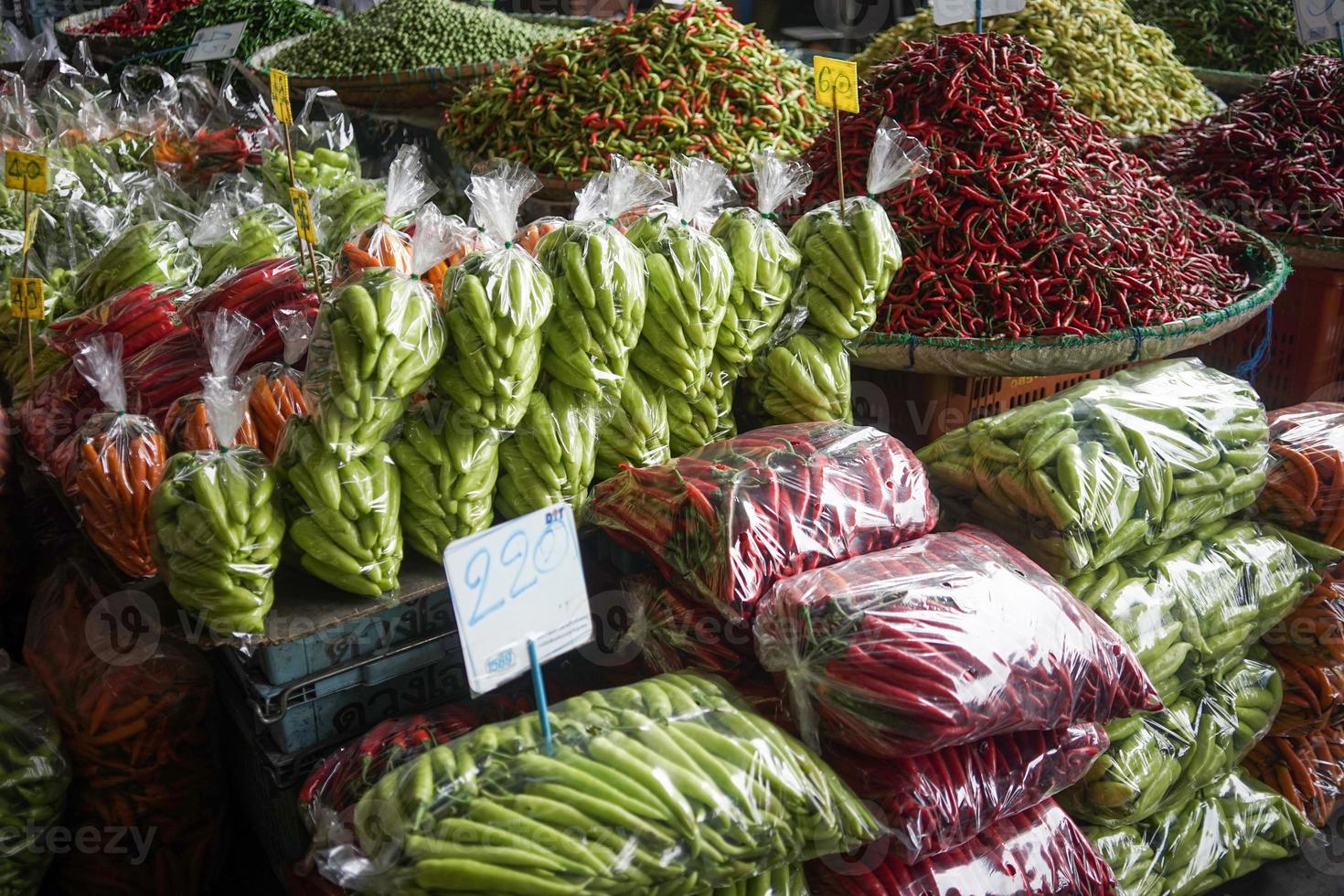 pilas de chile pimientos, empaquetado en el plastico pantalones para rebaja en el mercado. foto