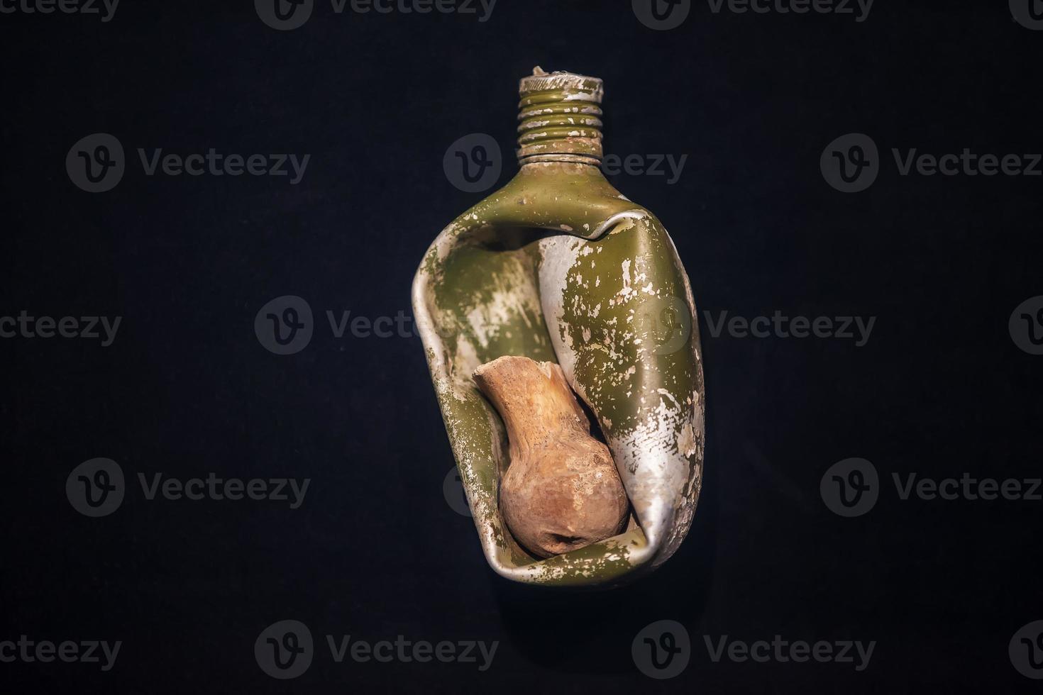 Military flask of the Second World War with the bone of a dead person during the explosion. photo