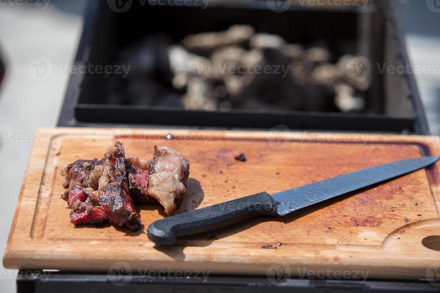 Cutting board, knife and slices of meat. photo