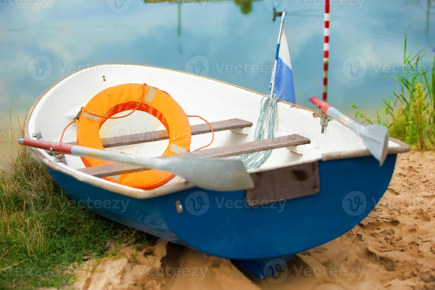 Rescue boat on the water with a life buoy and oars. photo
