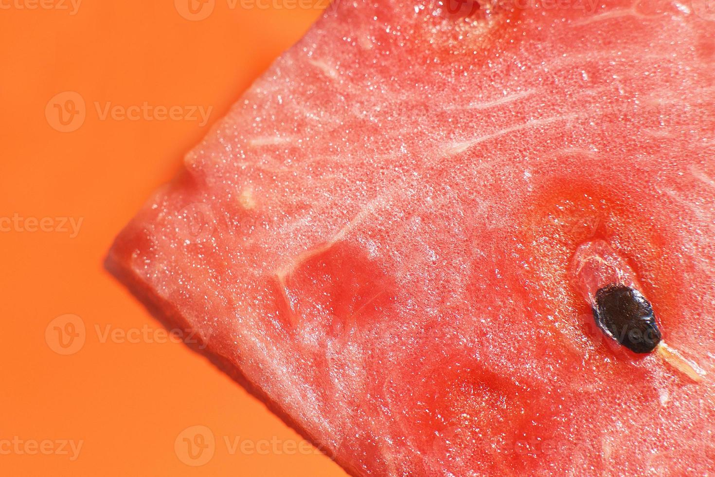 slice of watermelon on orange background close-up. watermelon seed macro photo