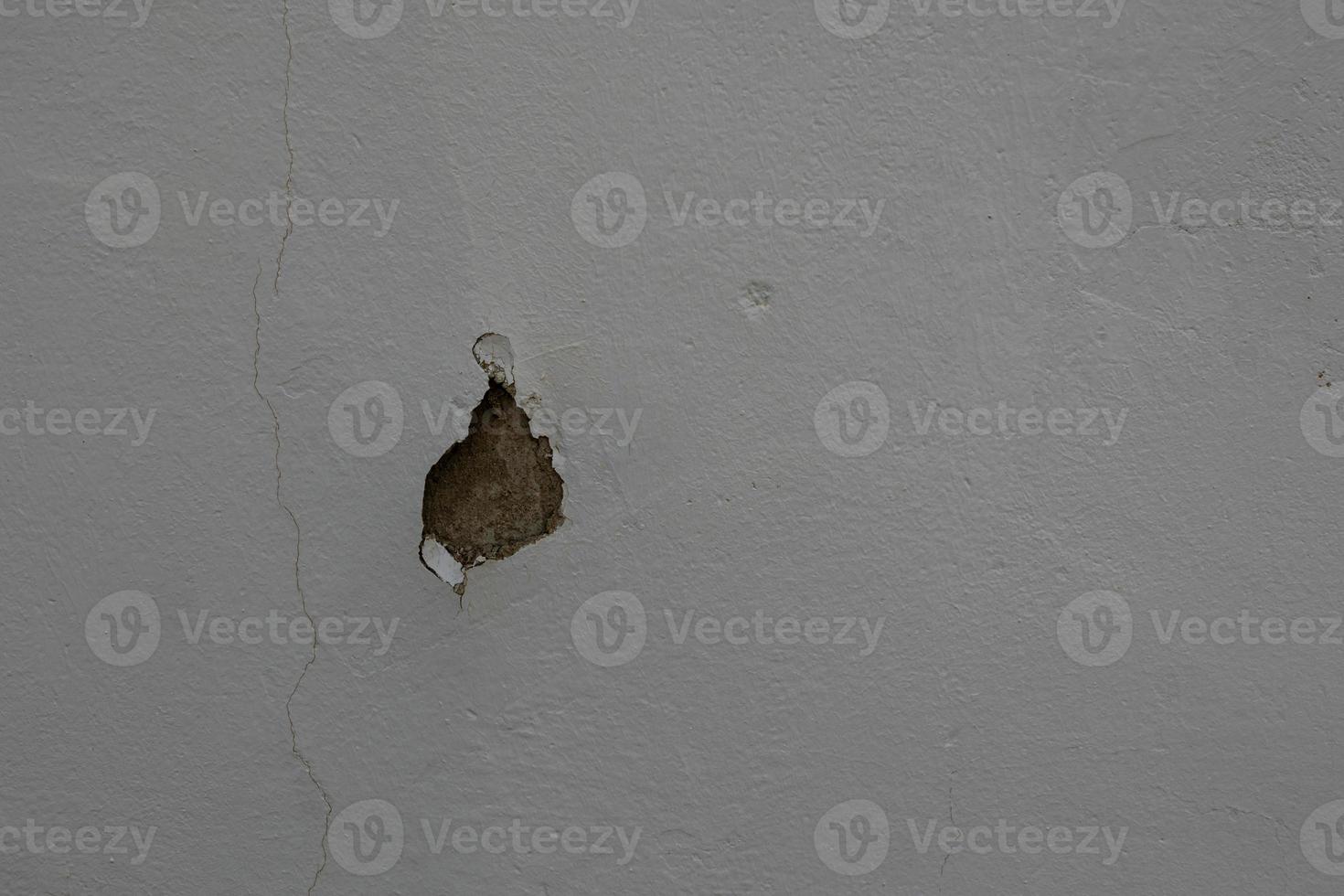 background of old gray wall with cracked plaster in close-up photo