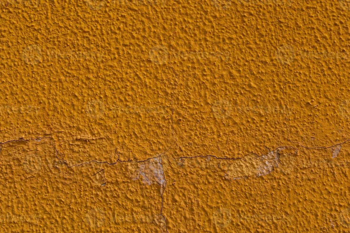 background of old colorful wall with cracked plaster in close-up photo