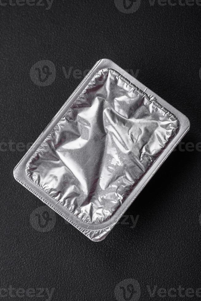 Rectangular plastic box with yogurt or cheese hermetically sealed with a foil lid photo