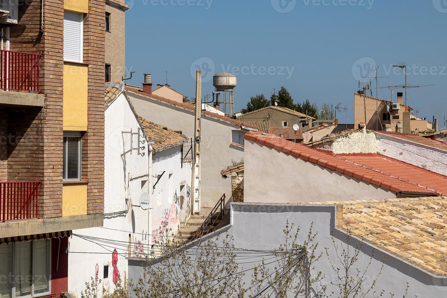 background with spanish tiled roofs of houses against a cloudless blue sky photo