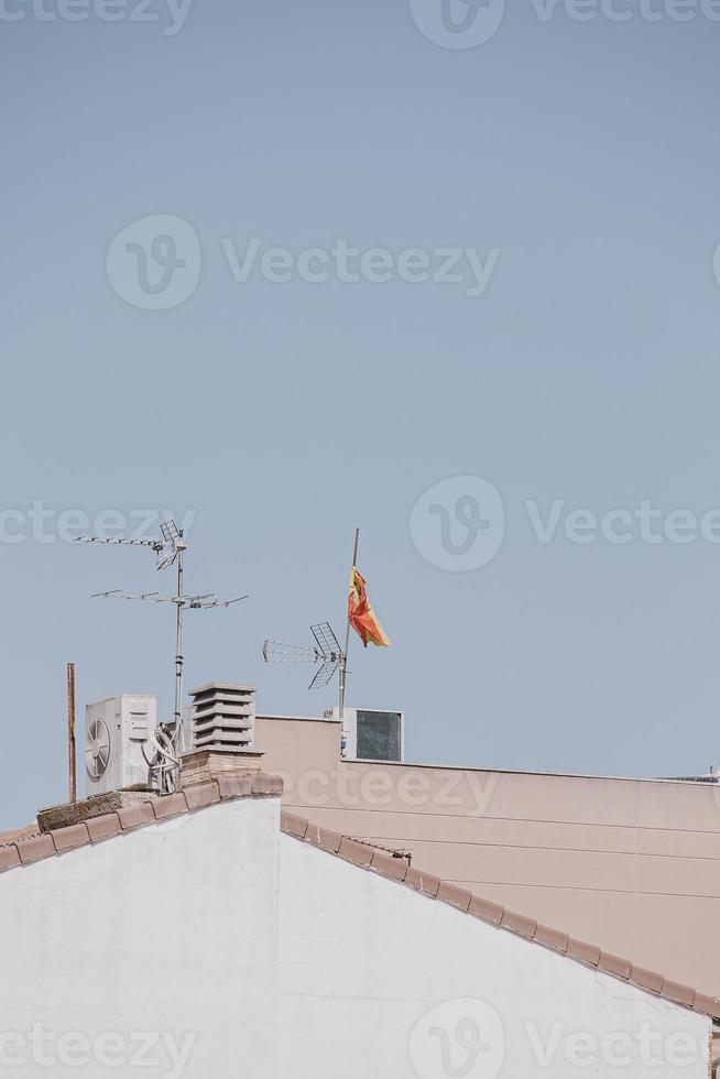 background with spanish tiled roofs of houses against a cloudless blue sky photo