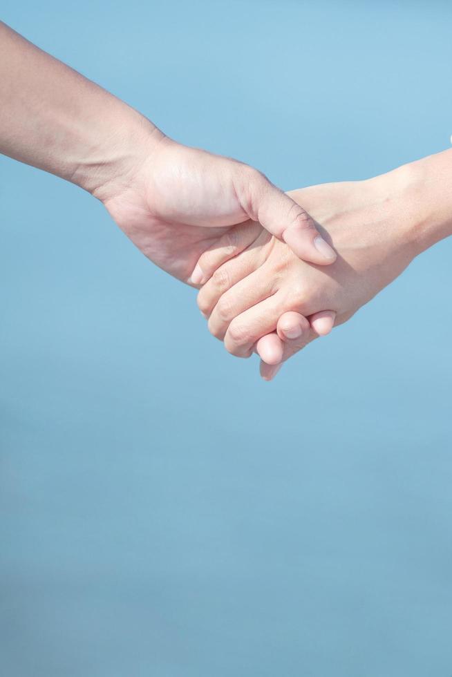 Couple love holding hands on blue sky and sea background. Valentines day and marriage Concept photo