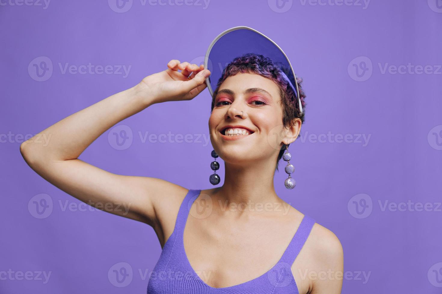 Fashion woman in bright purple sportswear portrait smiling and looking at camera on purple background and smiling photo