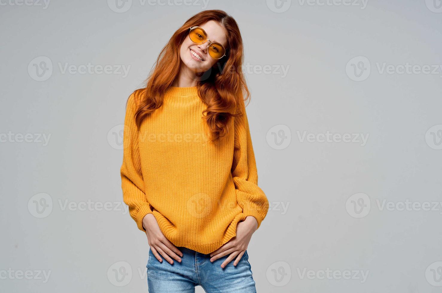 red-haired woman in yellow glasses posing fun lifestyle studio model photo