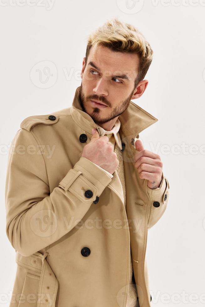 handsome man fashionable hairstyle beige coat side glance isolated background photo