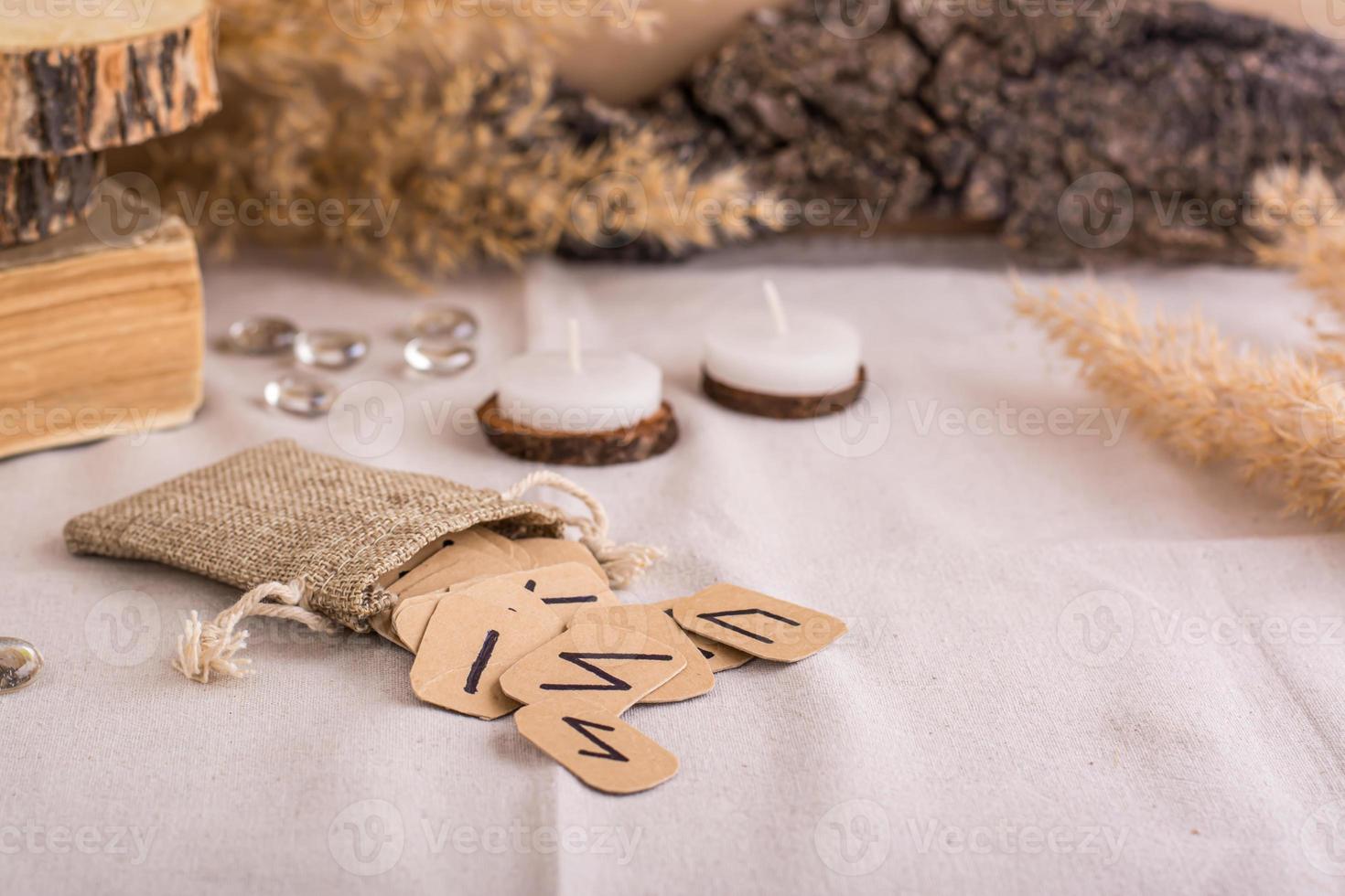 Handmade cardboard Scandinavian runes in a bag on a divination table photo