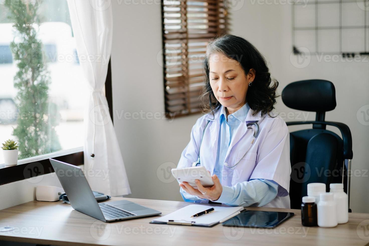 concepto de tecnología médica. Médico que trabaja con un teléfono móvil y un estetoscopio en la oficina moderna foto