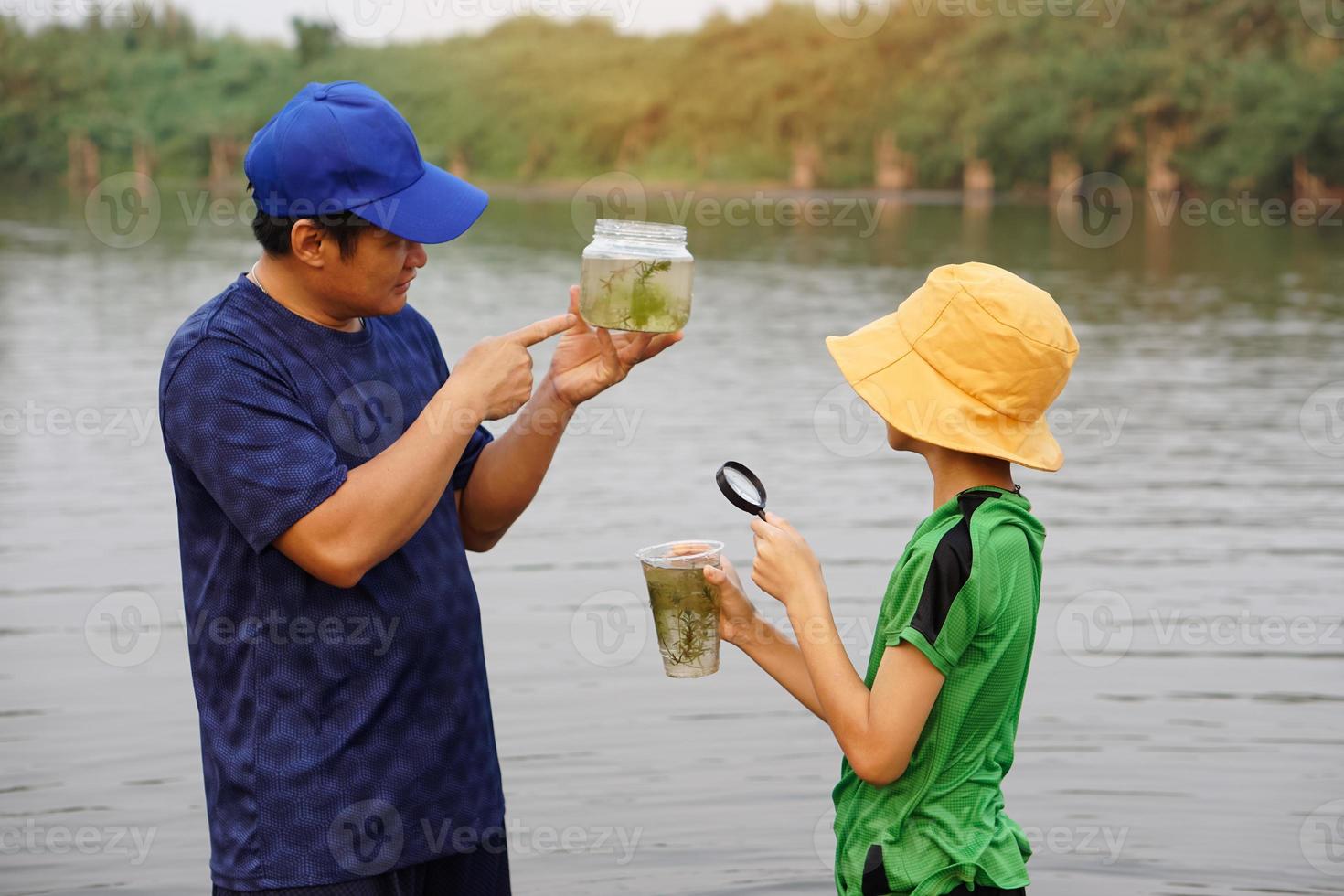 Asian man teacher and students are exploring water from nature source. Concept, Ecology and environment study. Outdoor summer camp activity. Education. Learning by doing. Life experience. photo