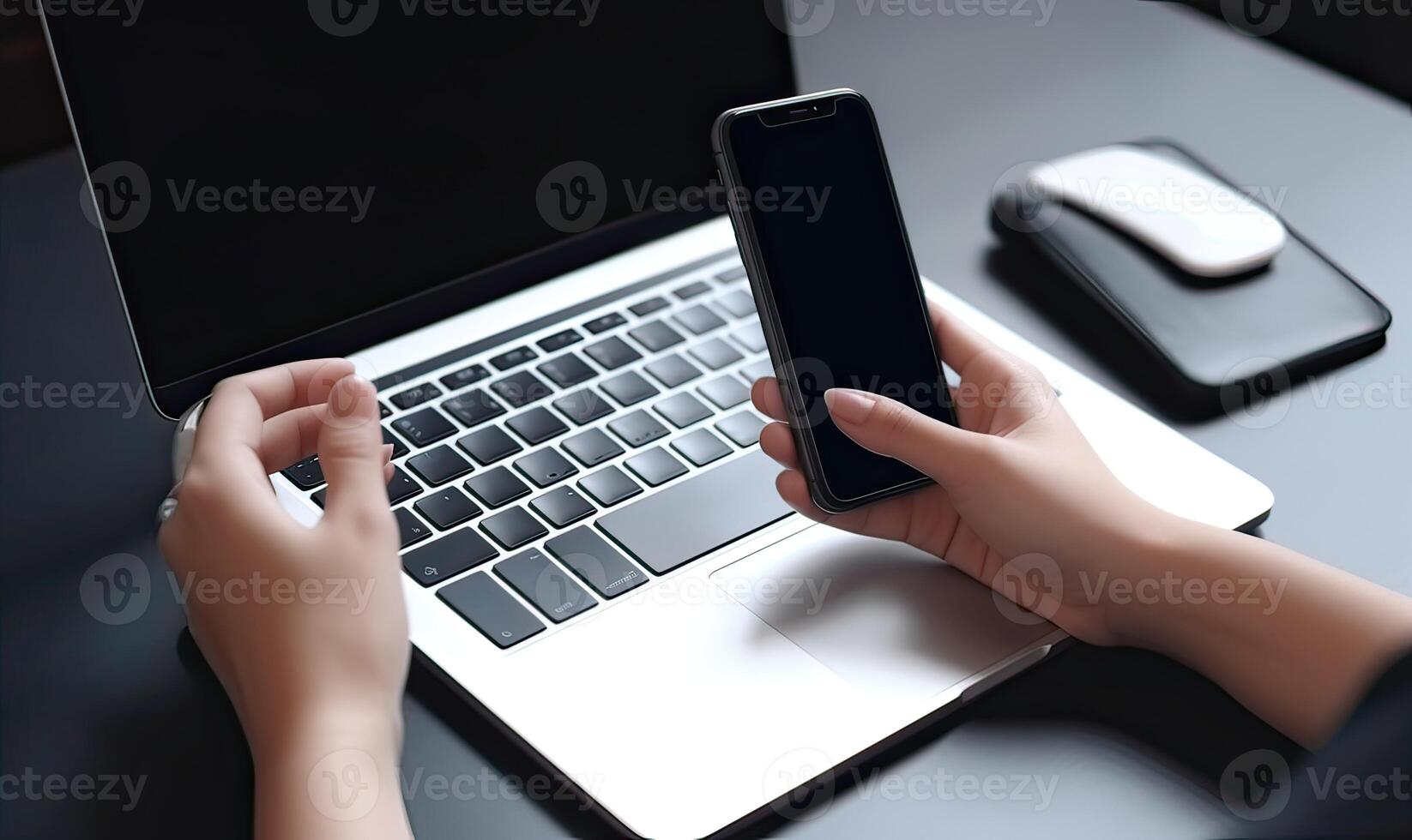 Close up view of hands holding mock up smart phone with laptop background. photo