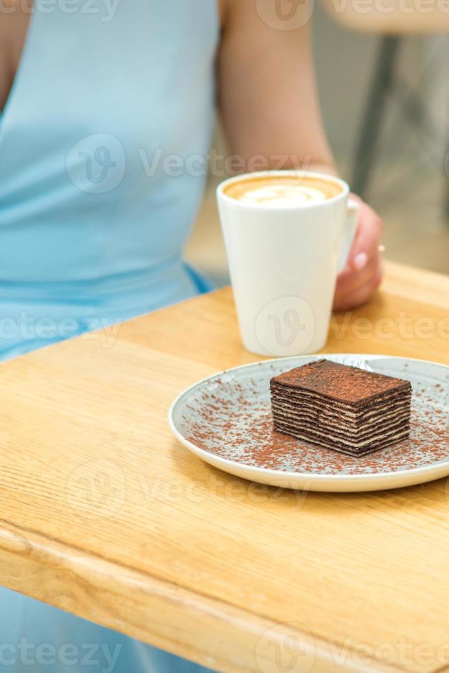 Young woman sitting at the table in cafe photo
