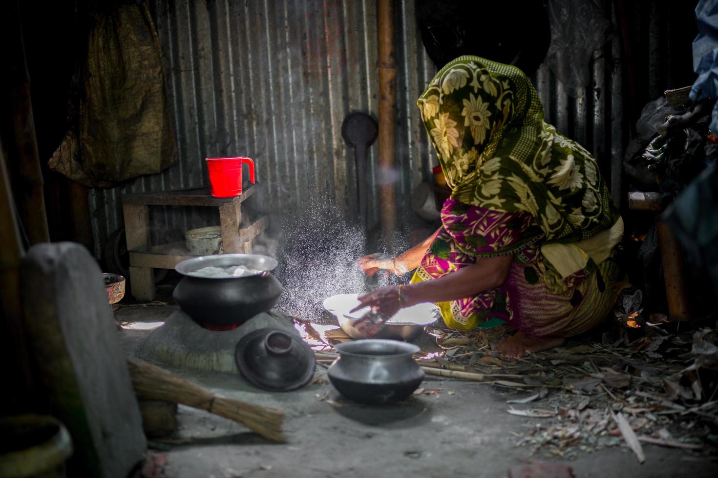 Bangladesh agosto 05, 2019 un mujer es Cocinando arroz pelotas en un tradicional carbonero arcilla estufa a narsingdi, bangladesh foto