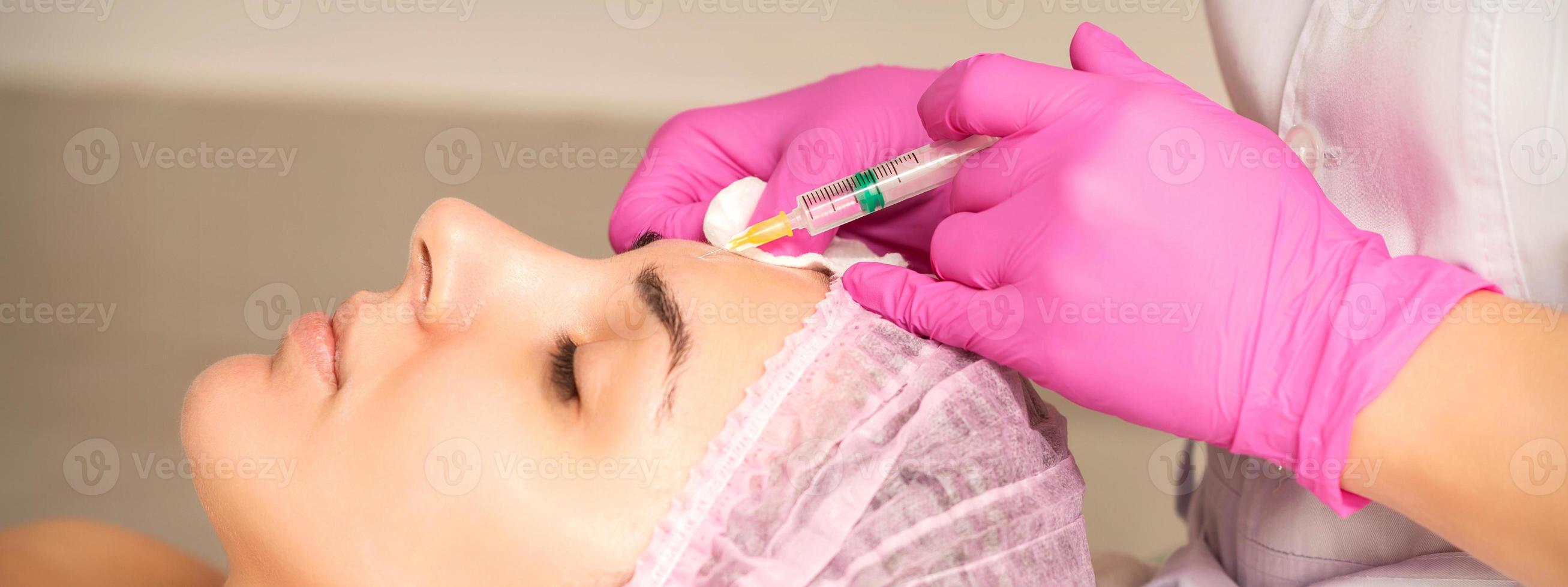 Woman receiving injection of botox photo