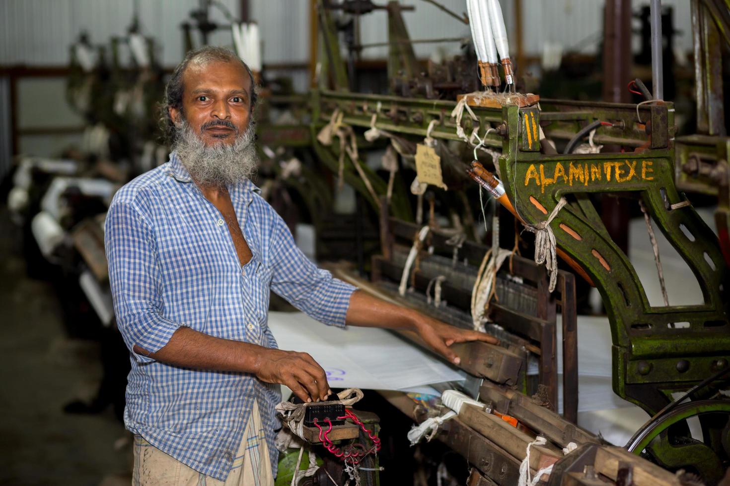 Bangladesh August 05, 2019 A yarn factory worker has made white cotton cloth in the machine at Narsingdi, Bangladesh. photo