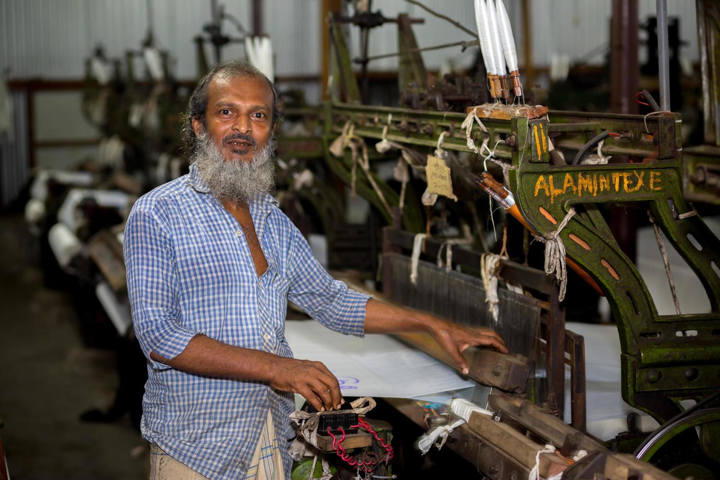 Bangladesh August 05, 2019 A yarn factory worker has made white cotton cloth in the machine at Narsingdi, Bangladesh. photo