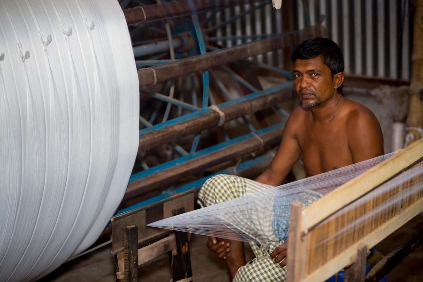 Bangladesh August 05, 2019 A factory worker makes white yarn spools for making clothes at Narsingdi, Bangladesh. photo