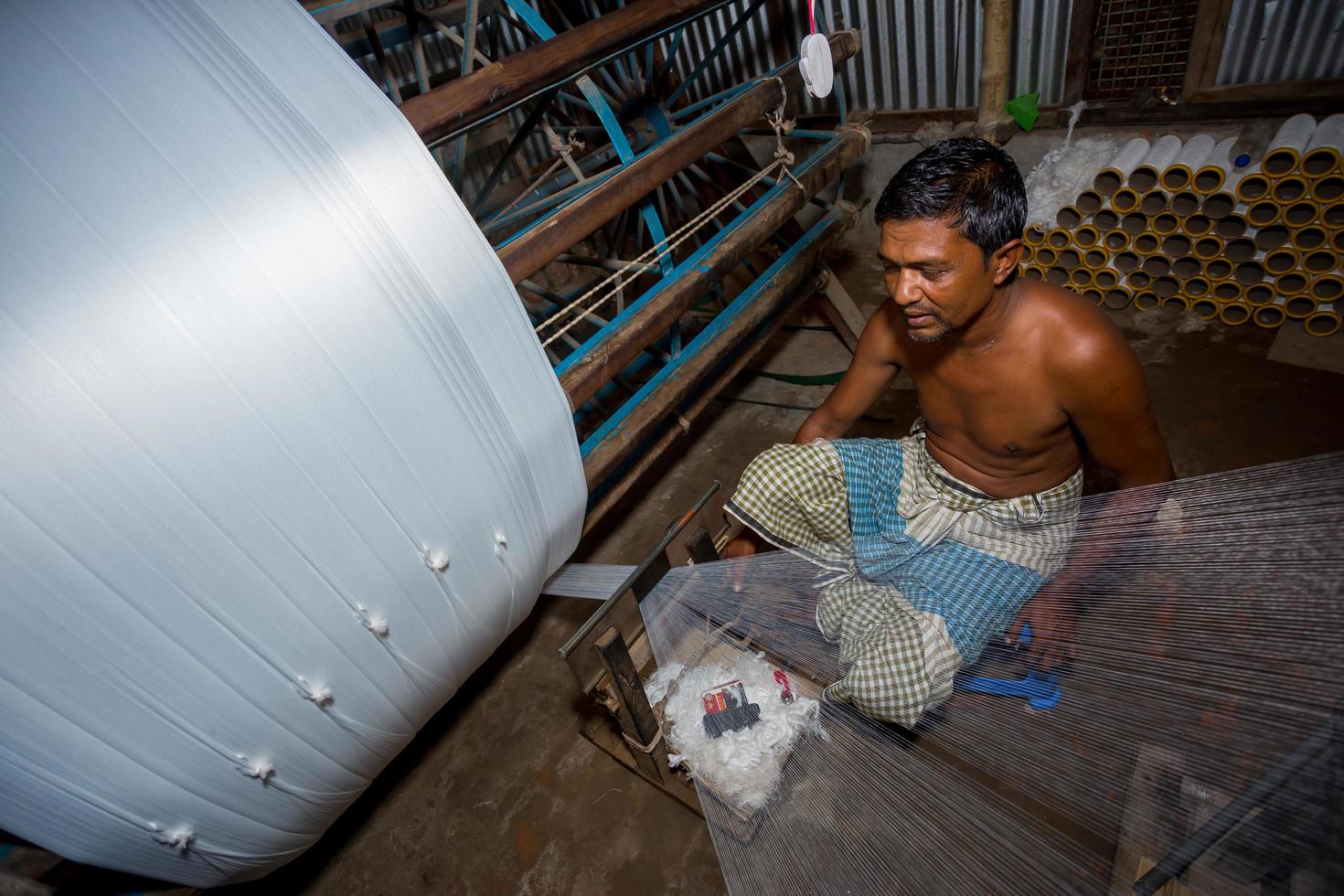 Bangladesh August 05, 2019 A factory worker makes white yarn spools for making clothes at Narsingdi, Bangladesh. photo