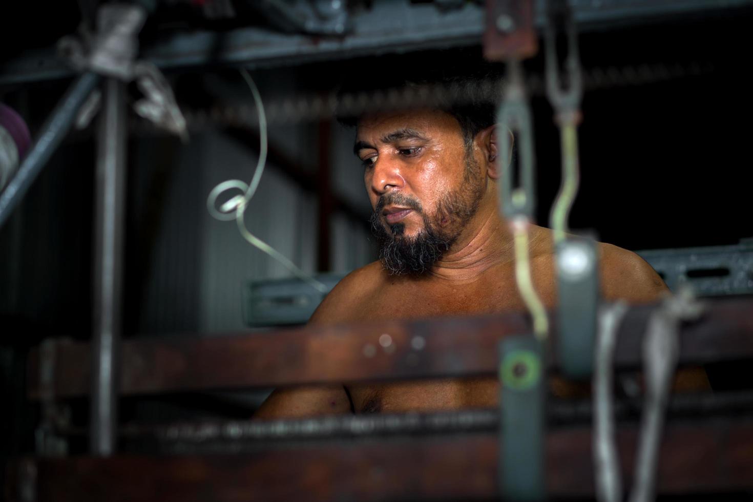 Bangladesh August 05, 2019 Portrait of a yarn factory worker operating a yarn machine at Narsingdi, Bangladesh. photo