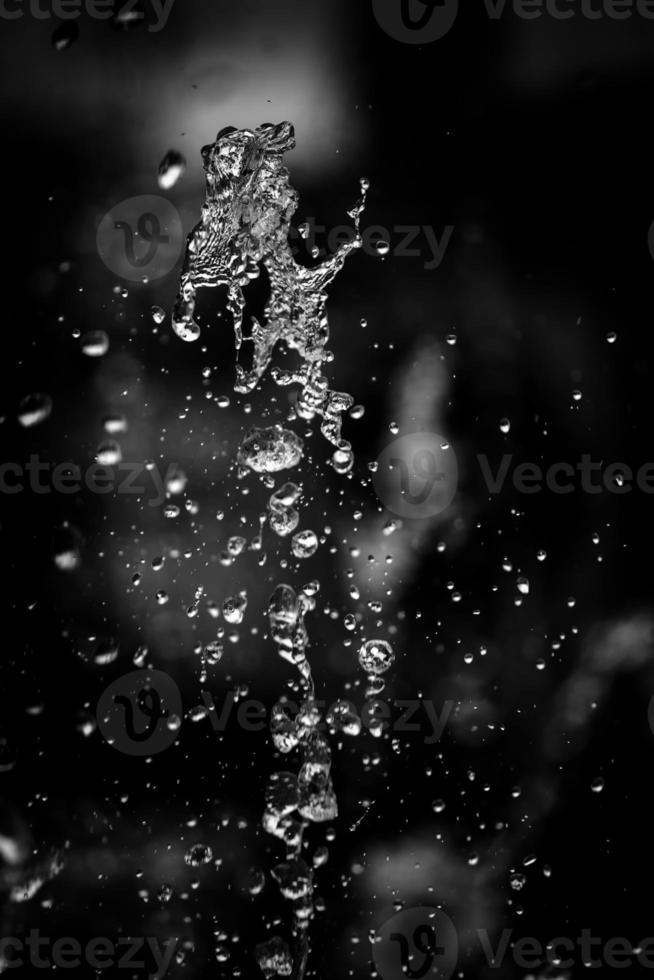 Water liquid splashing on isolated black background. photo