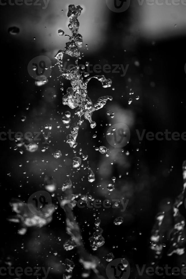 Water liquid splashing on isolated black background. photo