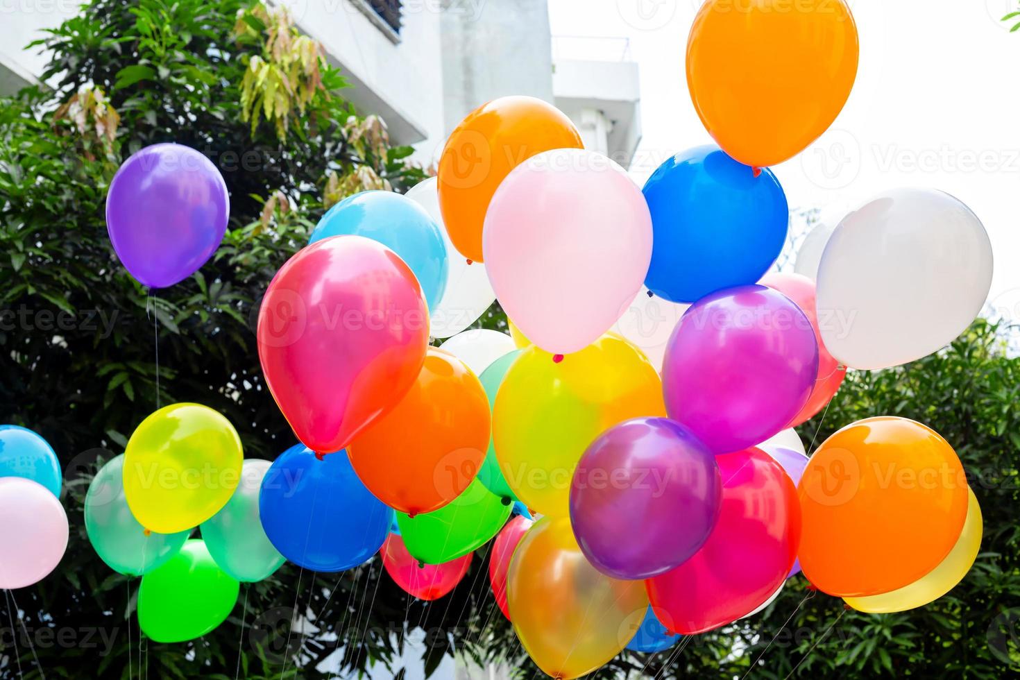 Colorful balloons filled with gas tied to the thread are flying. photo