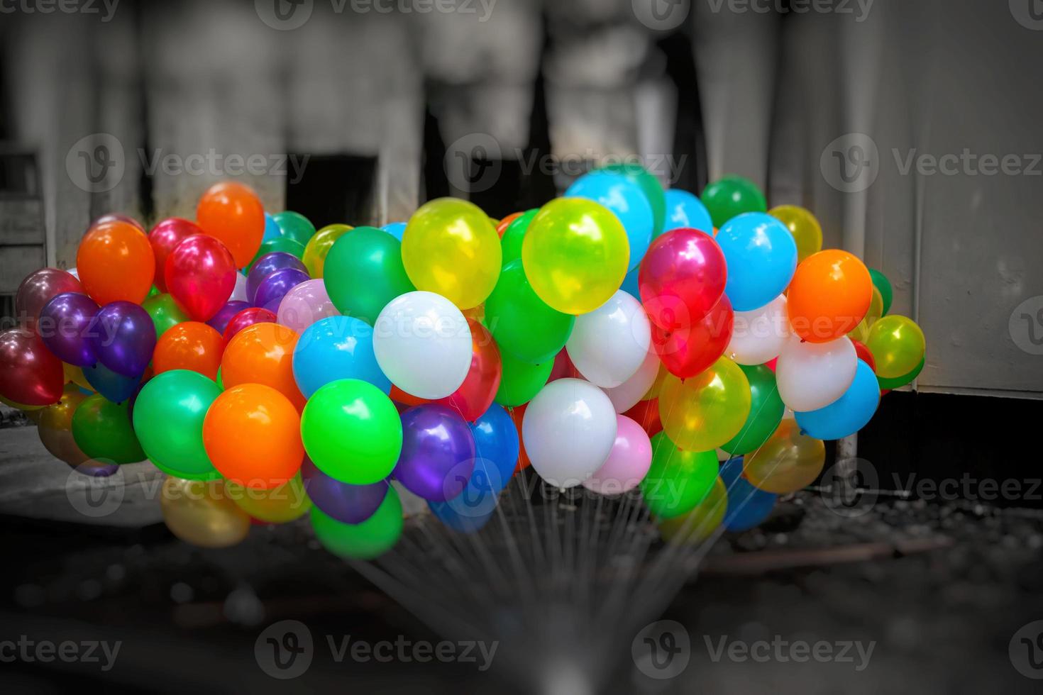 A bunch of colorful gas-filled balloons on dark background. photo