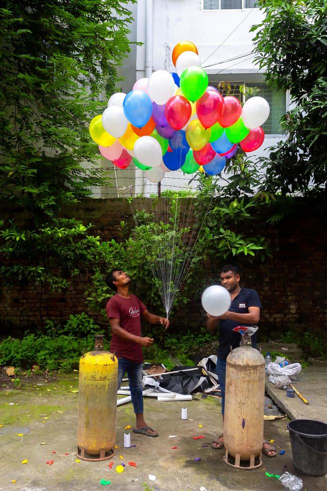 Bangladesh September 08, 2020 Two balloon sellers are injecting gas into some colorful balloons through two gas cylinders at Dhaka, Bangladesh. photo