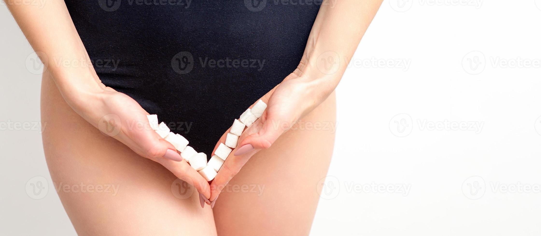 Woman holding sugar cubes on bikini zone, the concept of intimate depilation, problems of intimate hygiene. photo