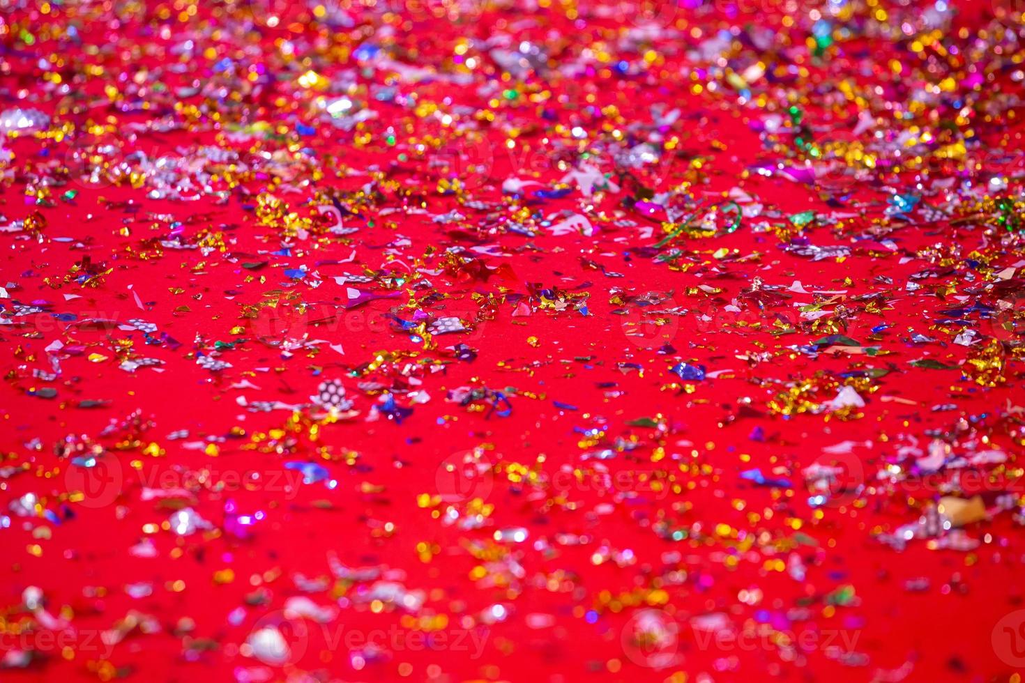 Gold or silver plastic laces cover on the red carpet. Red glitter texture abstract background. photo