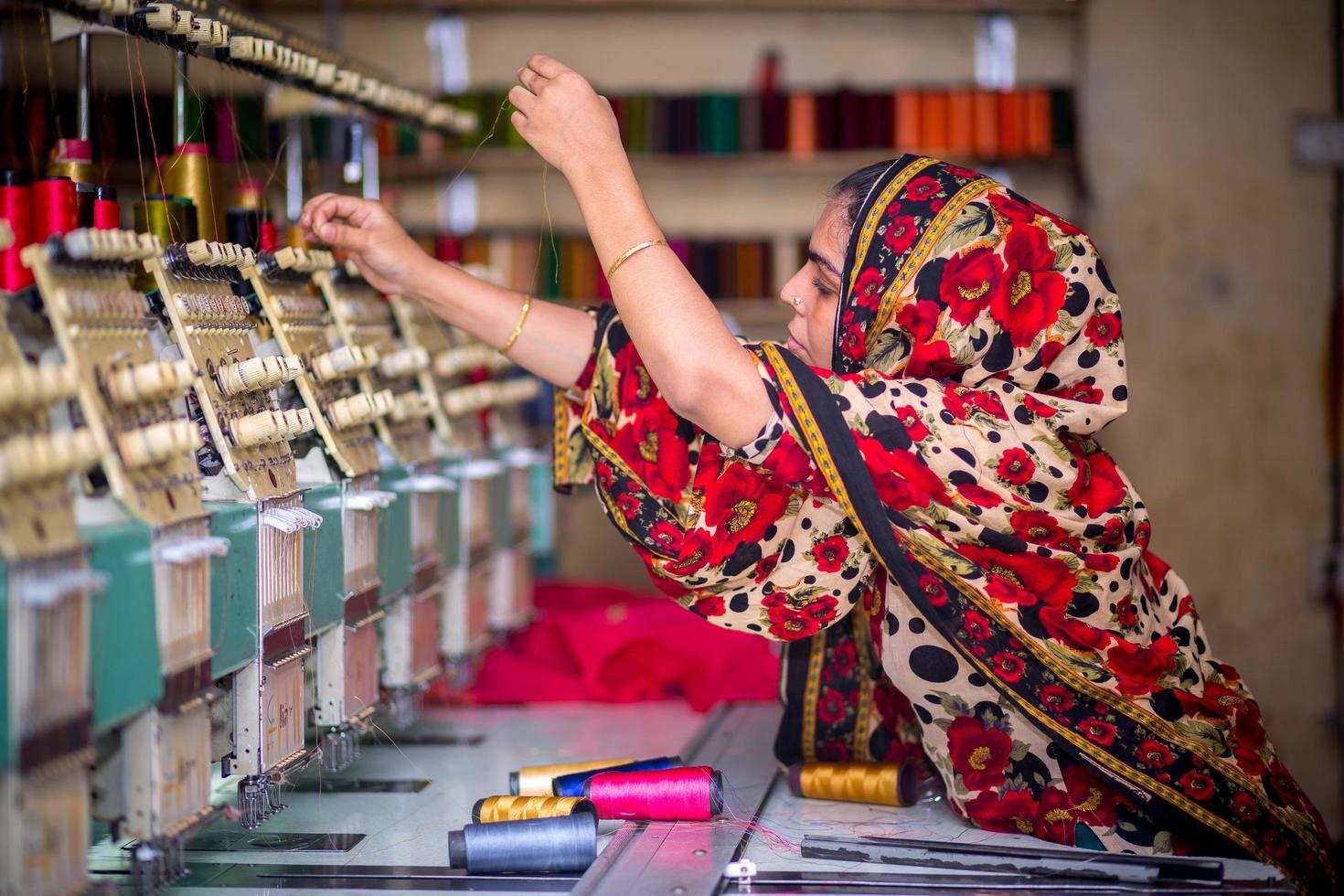 Bangladesh agosto 6, 2019 un bangladeshi mujer vestidos trabajador trabajando con computerizado bordado máquina a madhabdi, narsingdi, bangladesh foto