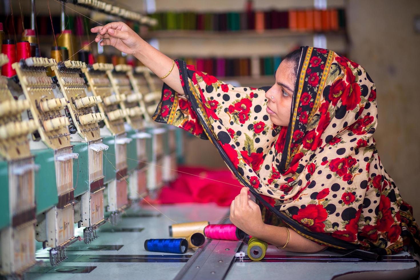 Bangladesh agosto 6, 2019 un bangladeshi mujer vestidos trabajador trabajando con computerizado bordado máquina a madhabdi, narsingdi, bangladesh foto