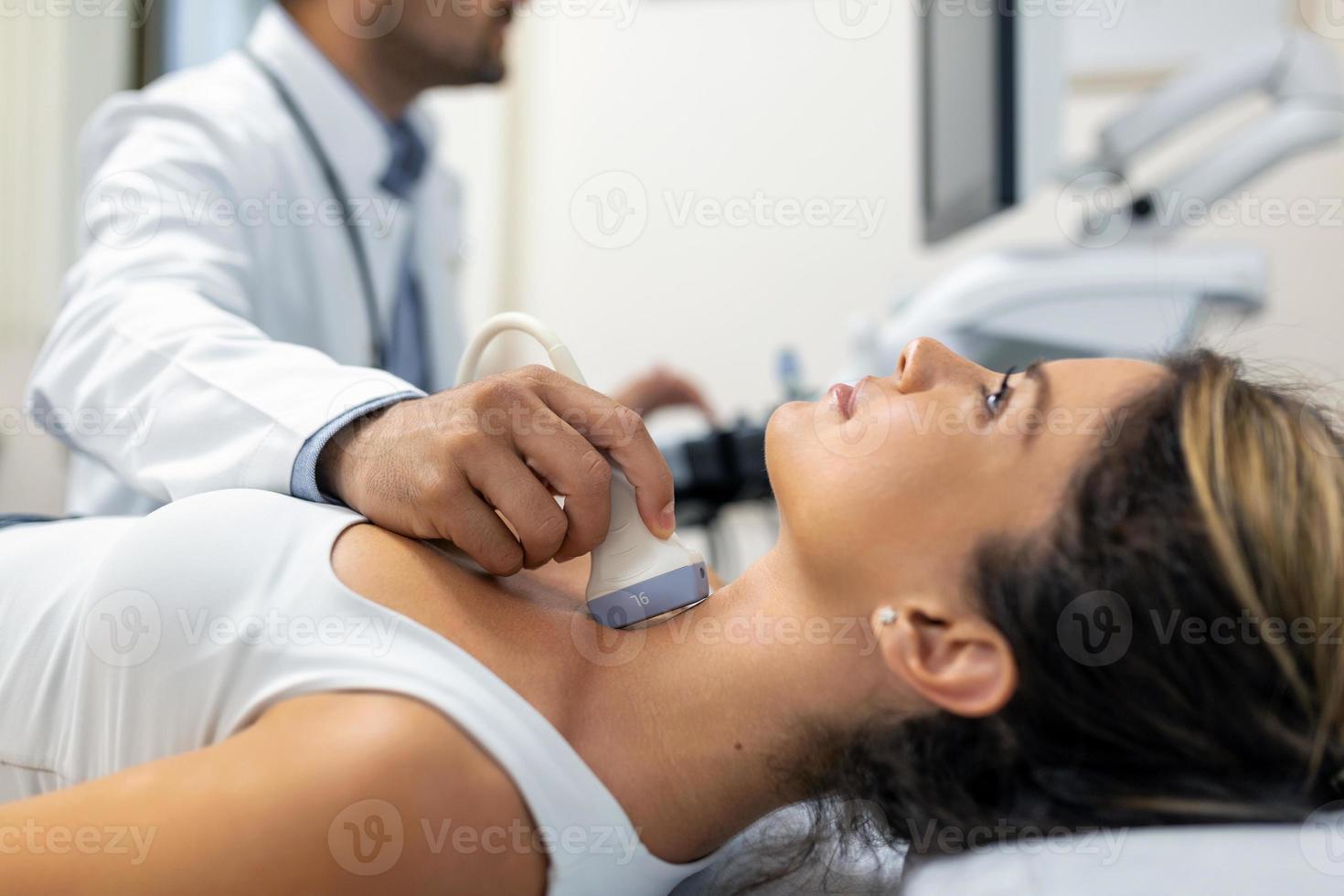 Close up shot of young woman getting her neck examined by doctor using ultrasound scanner at modern clinic photo