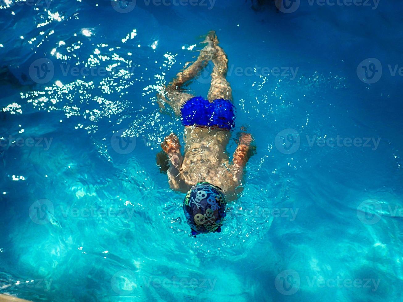 boy diving in the sea in blue water on a summer warm holiday day photo