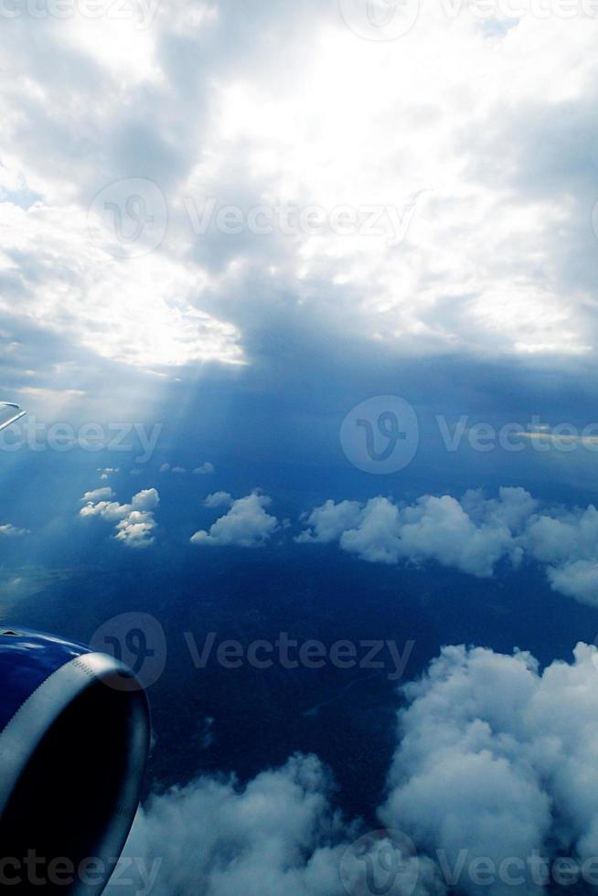 white clouds against the blue sky seen from the flight from the windows of the plane photo