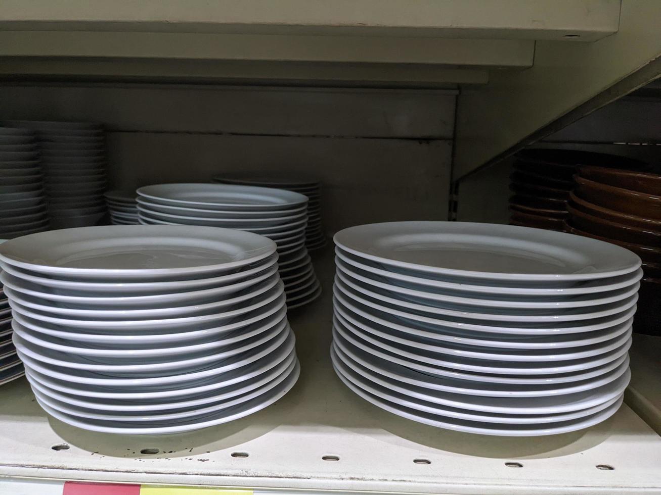 Lot of bowl and plate on the rack mini market. The photo is suitable to use for promotion picture and discount background.